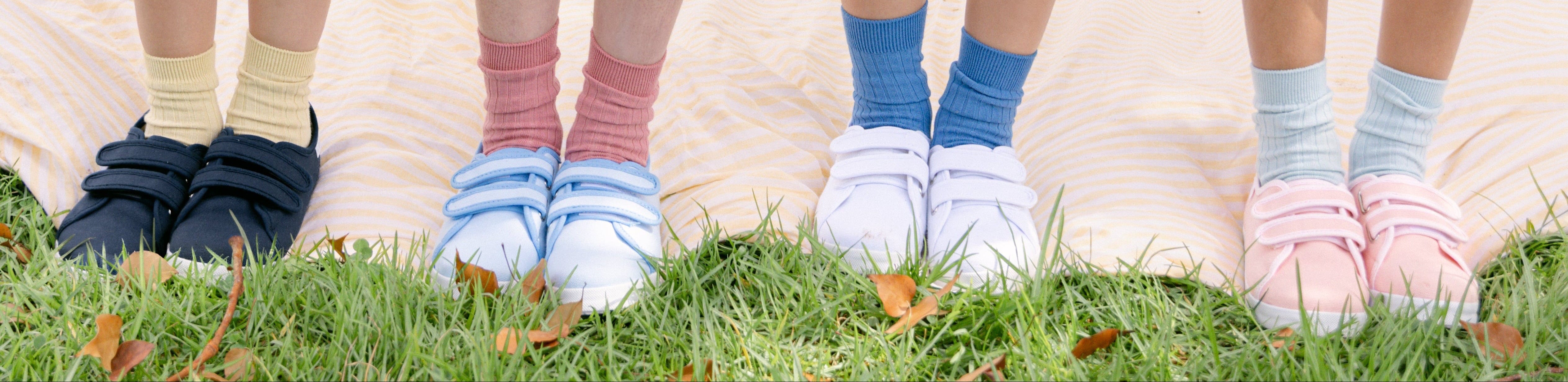 Children's feet wearing colorful socks on grass