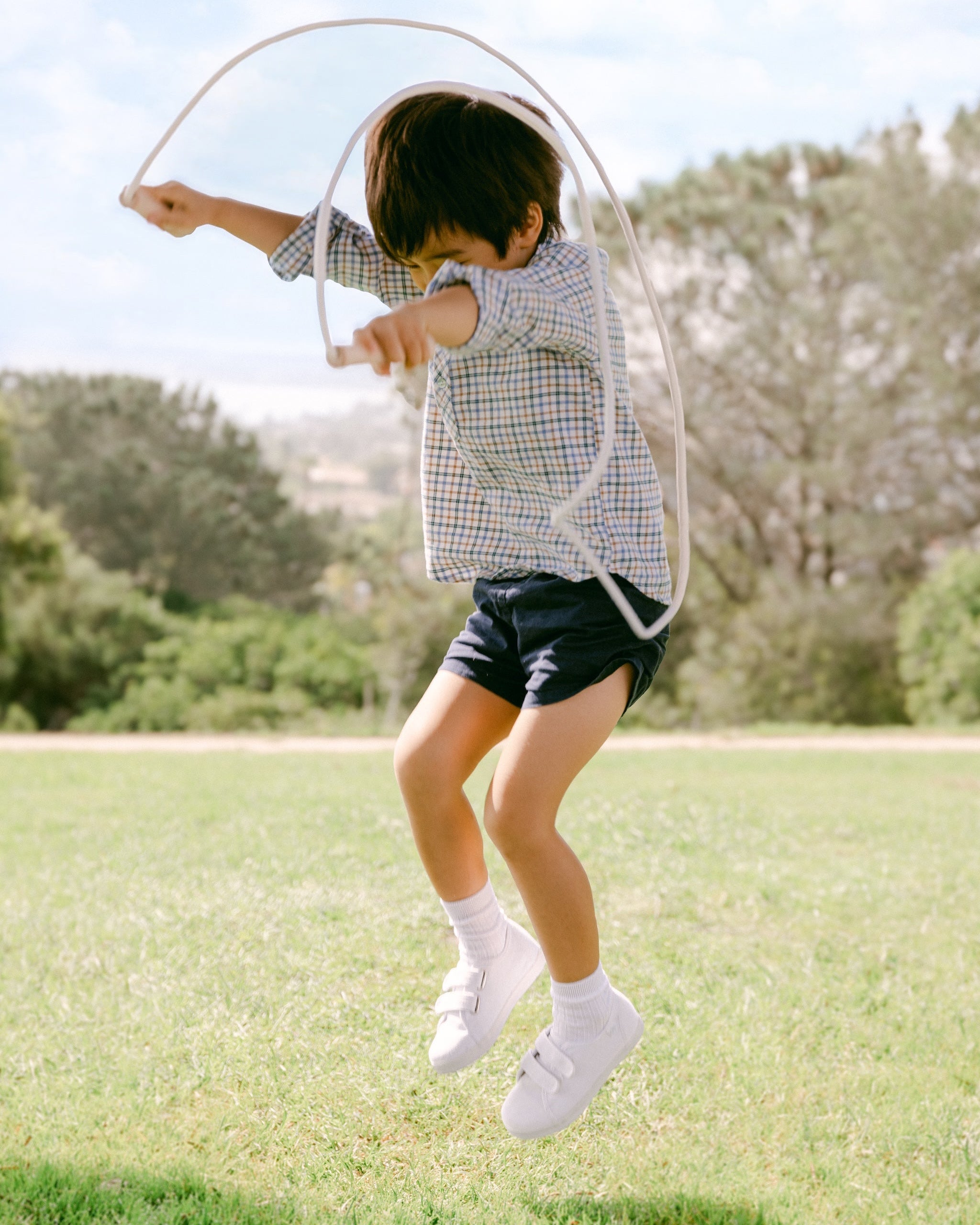 Child playing with a hula hoop in an outdoor setting