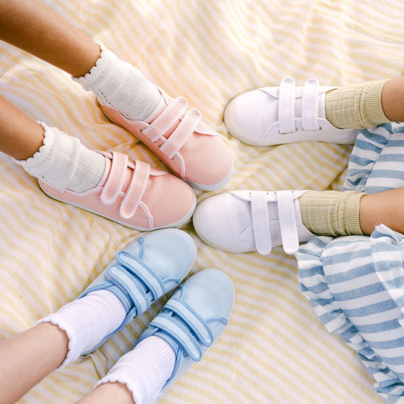 Children's feet wearing colorful socks and shoes on a soft surface